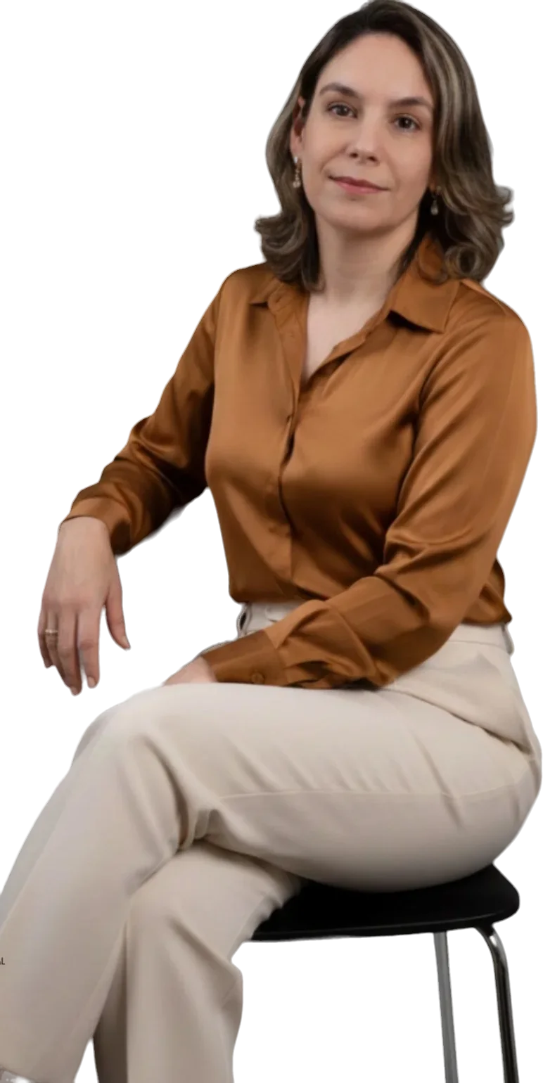 Dra. Eveline Saad sentada, de camisa caramelo, olhando para a câmera