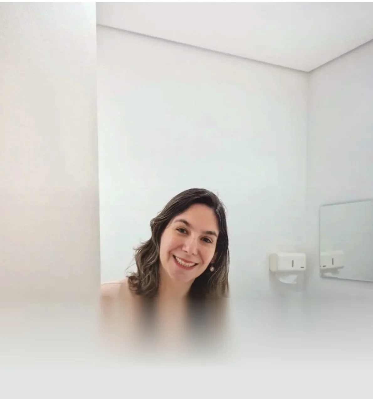 Dra. Eveline Saad sorrindo na porta da sala de atendimento, de paredes brancas, no Ibiza Office